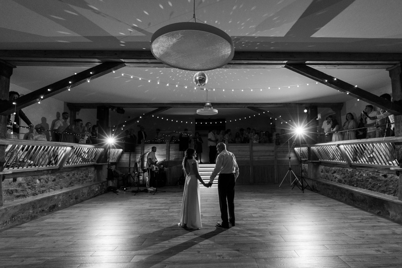 la mariée tient la main de son père en attendant le début de la musique pour l'ouverture de bal lors de la soirée de son mariage dans une salle magnifique