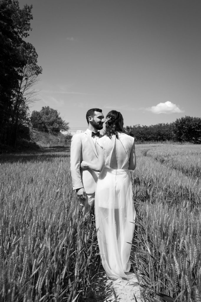 couple de mariés dans un champ de blé vert