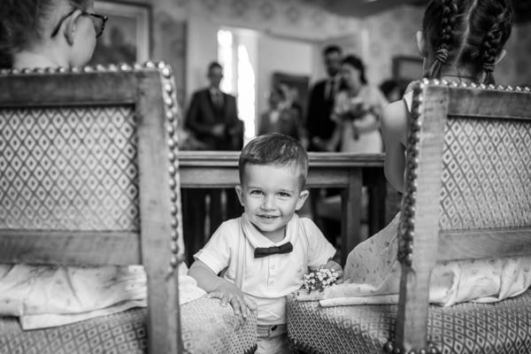 petit garçon à l'air malicieux pendant une cérémonie d'un mariage civil à la mairie