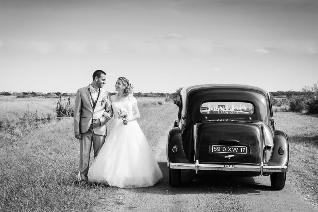 couple de mariés à côté de leur voiture deux chevaux dans les marais de Fouras lors de leur photo de mariage