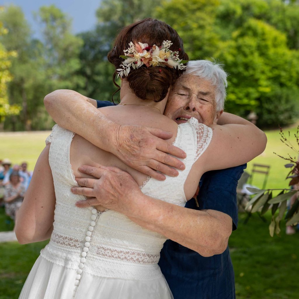 grand-mère qui serre la mariée dans ses bras